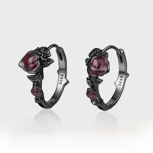 Vue macro du poinçon S925 sur boucles d'oreilles roses gothiques noires et rouges