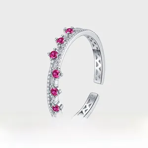 Detail of adjustable silver ring with hollow patterns and crown-set pink zircons