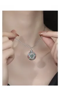 Détail macro du pendentif rond en argent S925 avec zircon cœur vert et maille colorée