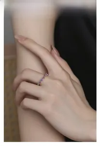 Detail of wavy S925 silver ring with rose pink zircons on finger for daily wear