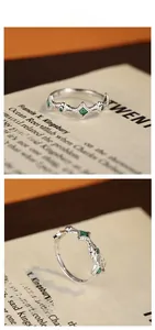 Macro detail of S925 sterling silver ring featuring emerald zircon and leaf engraving