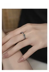 Macro shot of S925 silver ring with emerald stone and intricate floral leaf engraving