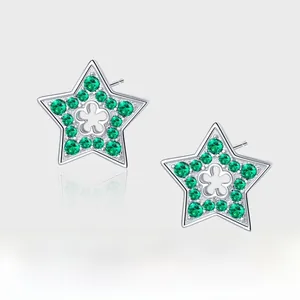 Macro detail of 925 sterling silver star stud earrings with green cubic zirconia and clover