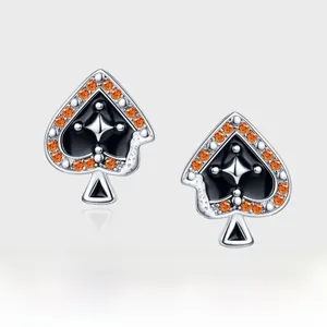 Detail of spade earring with black enamel, star inlay and orange gemstone border
