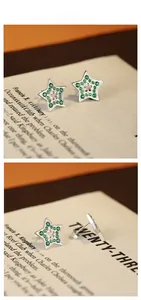 Macro shot of 925 silver star earrings with green zircon pavé and hollow floral center