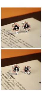 Detail of 925 sterling silver Ace of Spades studs with orange zircon and black enamel