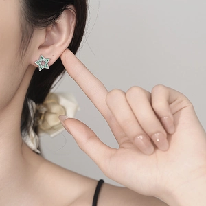 925 silver star stud earrings with green zircon pave and hollow clover worn on ear