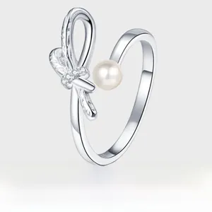 Macro detail of S925 silver bow ring featuring white pearl and shimmering zircon stones