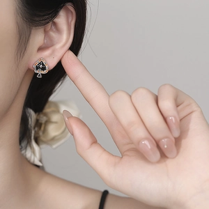 925 silver Ace of Spades stud earring with orange zircon on model's ear