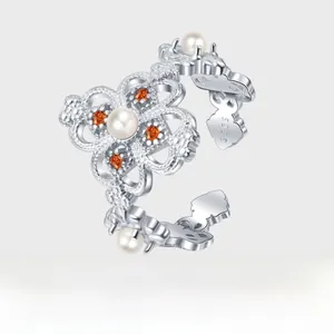 Detail of S925 silver open ring with white pearl and orange gemstone inlay