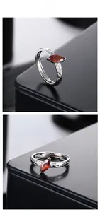 Detail of S925 silver ring with marquise red zircon and hammered texture finish