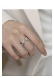 Detail of silver horseshoe ring with cubic zirconia on female hand in office outfit
