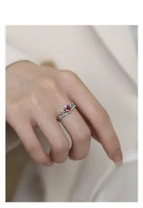 Nahaufnahme eines S925 Silber-Kronenrings mit rotem Zirkon-Herz an einem Model-Finger