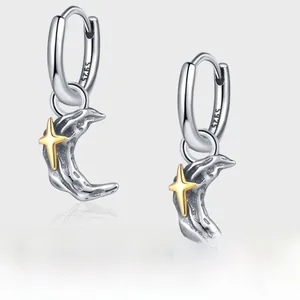 Detailed close-up of S925 sterling silver crescent moon earrings with golden star accent