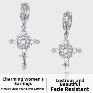 Vue détaillée des boucles d'oreilles croix rétro en argent avec perles et zircons brillants