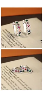 Macro detail of wave-shaped S925 silver hoop earrings with five colorful rectangle stones