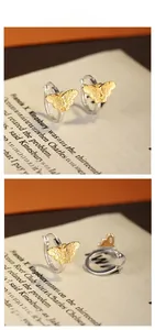 Detail of S925 silver butterfly earrings with golden hammer texture and two-tone finish