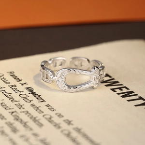 Vintage S925 sterling silver horseshoe ring with floral carvings on aged paper background
