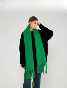 Close-up of bright green knit scarf texture featuring soft tassels and plush fiber detail