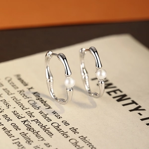 S925 silver bamboo hoop earrings with white pearls on a vintage paper background