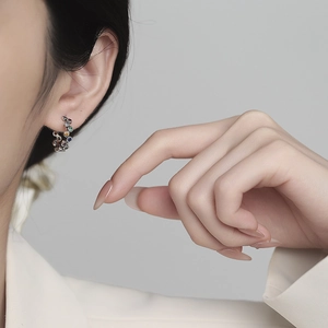 Rainbow C-shaped S925 silver stud earrings with colorful faceted gems on a model