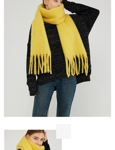 Detail of bright yellow soft mohair scarf with long fringe tassels on casual outfit