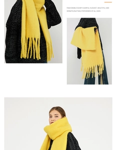 Detail of yellow knit mohair scarf featuring long fringe tassels and soft fluffy texture