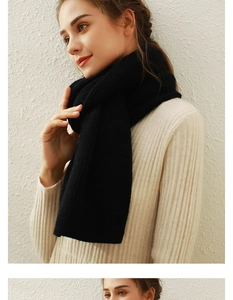 Detailed view of thick black knitted scarf texture with warm winter styling on model