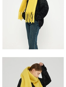 Detail of yellow knit scarf showing soft texture and long tassels on the ends