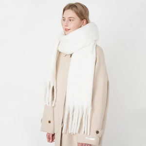 Soft white faux cashmere scarf with long tassels paired with a beige coat for winter warmth