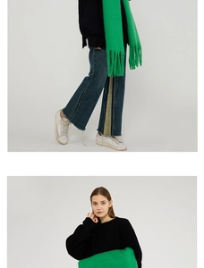 Detail of bright green knit scarf featuring thick fringe tassels and a soft textured finish