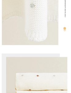 Detail of white cotton knit blanket with colorful crochet dots and soft texture finish