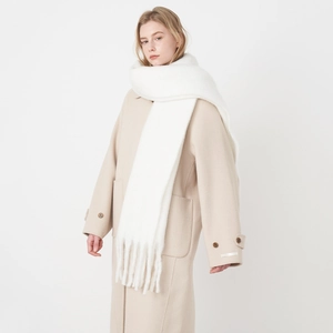 Extra long white cashmere-feel scarf with tassels worn over a stylish beige wool coat