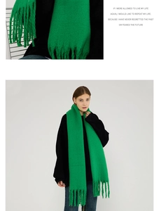 Detailed close-up of vibrant green mohair scarf with long tassels and chunky knit texture