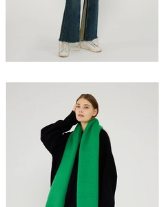 Detail showing bright green soft mohair scarf on a black sweater for winter style