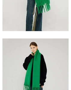 Detailed view of bright green knit scarf featuring long fringe tassels and soft texture