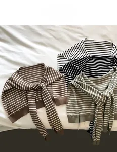 Close-up of striped knit shawls in brown, black, and green colors with long ties