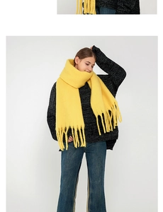 Detail shot of bright yellow mohair scarf with thick long tassels for winter warmth