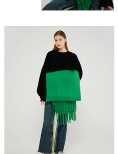 Detail of bright green mohair scarf with long tassels and chunky knit texture