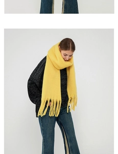 Close-up of bright yellow thick mohair scarf showing soft fuzzy texture and long tassels