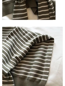 Detailed view of the striped knit shawl showing dark green and khaki ribbed textures