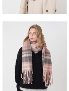 Détail d'une écharpe d'hiver à carreaux doux avec franges rose, gris et crème