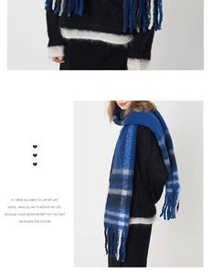 Détail d'une écharpe à carreaux bleu et gris avec de larges franges et texture cachemire