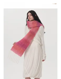 Dettaglio macro di morbida sciarpa in lana mohair sfumata rosa con eleganti frange bianche