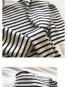 Close-up of fine black and white striped knit texture with ribbed edges on a shawl