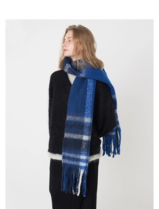 Détail d'une écharpe à carreaux bleu foncé avec de longues franges et un motif classique