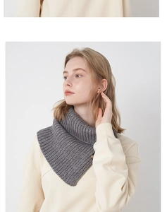 Detail of dark grey wool blend knit neck warmer with ribbed texture and button detail