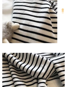 Close-up of soft black and white striped knit shawl with high-quality fabric texture