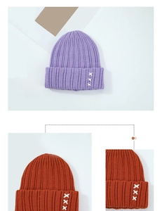 Détail du bonnet en maille côtelée épaisse avec broderie XXX blanche et revers plié