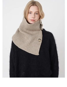 Detail of khaki wool knit neck warmer featuring a large tortoiseshell button closure